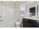 Bright bathroom features a white tub with tile surround and a vanity with black cabinets at 368 Sawyer Meadow Way, Grayson, GA 30017