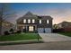 Charming two-story brick home with a well-manicured lawn and a two-car garage at dusk at 368 Sawyer Meadow Way, Grayson, GA 30017