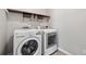 Functional laundry room with white washer and dryer, overhead shelf, and ample space at 368 Sawyer Meadow Way, Grayson, GA 30017