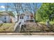 Inviting exterior of a raised cottage home with white stairs leading to a red front door on a treed lot at 944 Joseph E Boone Nw Blvd, Atlanta, GA 30314