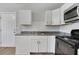 Galley kitchen featuring white cabinets, stainless steel microwave, and sleek countertops at 944 Joseph E Boone Nw Blvd, Atlanta, GA 30314
