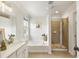 Bathroom with a separate tub and tiled shower, complemented by natural light from a window at 11265 Musette Cir, Alpharetta, GA 30009