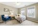 Bedroom featuring a cozy bed, blue chair, natural light, and charming decor at 11265 Musette Cir, Alpharetta, GA 30009