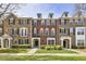 Charming brick townhome featuring black shutters, manicured landscaping, and inviting front entrances at 11265 Musette Cir, Alpharetta, GA 30009