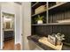 Stylish hallway boasts built-in shelves, a plant, and a glimpse into a powder room with patterned wallpaper and a mirror at 11265 Musette Cir, Alpharetta, GA 30009