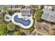Aerial shot of a unique community pool, surrounded by lush greenery, a fence and a clubhouse at 11265 Musette Cir, Alpharetta, GA 30009