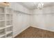 Walk-in closet providing ample storage, wood flooring, and a stylish light fixture at 11265 Musette Cir, Alpharetta, GA 30009