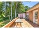 Spacious deck with brick exterior and lush green surroundings, perfect for relaxing and entertaining outdoors at 1211 Liverpool Pointe, Lawrenceville, GA 30046
