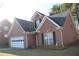 Charming brick home featuring a two-car garage and well-maintained landscaping at 1211 Liverpool Pointe, Lawrenceville, GA 30046