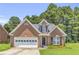 Charming single-story brick home with attached garage, landscaped yard, and lush green trees surrounding at 1211 Liverpool Pointe, Lawrenceville, GA 30046