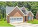 A cozy single-story brick home with an attached garage and well-maintained landscaping with lush green lawn at 1211 Liverpool Pointe, Lawrenceville, GA 30046