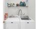 Functional laundry room with a shelf and stacked washer and dryer at 1211 Liverpool Pointe, Lawrenceville, GA 30046