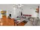 Bright and airy living room featuring hardwood floors, large sectional sofa, and view into eat-in kitchen at 1211 Liverpool Pointe, Lawrenceville, GA 30046