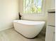 Bright bathroom featuring modern soaking tub under window, with wood-style flooring at 2863 Landing Dr, Marietta, GA 30066