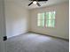 Bedroom featuring a ceiling fan, light gray carpet, and a view of nature through the large window at 2863 Landing Dr, Marietta, GA 30066