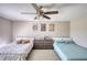 Shared bedroom with twin beds separated by a dresser and decorated with ceiling fan and neutral wall art at 610 Loth Wages Rd, Dacula, GA 30019