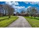 Charming single-story home with a long driveway and well-maintained landscaping, under a bright, partly cloudy sky at 610 Loth Wages Rd, Dacula, GA 30019