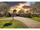 Single-story home with brick and stone facade, a basketball hoop, and a long driveway at sunset at 610 Loth Wages Rd, Dacula, GA 30019