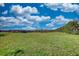 Vast grassy land under a blue sky with fluffy clouds, offering endless possibilities for building or recreation at 610 Loth Wages Rd, Dacula, GA 30019