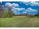 Lush grassy land under a bright sky with fluffy clouds, great for development or investment opportunities at 610 Loth Wages Rd, Dacula, GA 30019