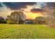 A picturesque land featuring a weathered outbuilding and lush greenery under a sky illuminated by a colorful sunset at 610 Loth Wages Rd, Dacula, GA 30019