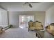 Cozy living room with plush carpeting, comfortable sofas, and a sliding glass door to the sunroom at 610 Loth Wages Rd, Dacula, GA 30019