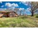 Brick single-story home with an enclosed patio and large yard with mature trees under a partly cloudy sky at 610 Loth Wages Rd, Dacula, GA 30019