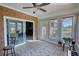 Cozy sunroom with brick accent wall, tile flooring, and sliding glass door access to the backyard at 610 Loth Wages Rd, Dacula, GA 30019