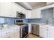 Bright kitchen features white cabinets, marble countertops, stainless steel appliances and stylish backsplash at 2161 Peachtree Ne Rd # 907, Atlanta, GA 30309