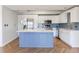 Bright kitchen features white cabinetry, stainless appliances, and a blue island with marble countertop at 2161 Peachtree Ne Rd # 907, Atlanta, GA 30309
