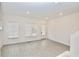Well-lit living room with wood floors, a back door, and multiple windows with bright white trim at 4209 Tifton Ln, Sugar Hill, GA 30518