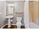 This small bathroom includes a classic sink, tile shower, and hardwood floors at 5485 Woodrun Ln, Johns Creek, GA 30005