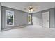 This bedroom offers neutral carpeting, a ceiling fan, and large windows at 5485 Woodrun Ln, Johns Creek, GA 30005