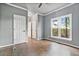 Empty bedroom with hardwood floors, grey walls, large window, and natural light at 5485 Woodrun Ln, Johns Creek, GA 30005