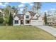 Attractive two-story home with a brick exterior, manicured lawn, and a driveway at 5485 Woodrun Ln, Johns Creek, GA 30005