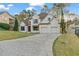 Beautiful two-story home with a brick exterior, manicured lawn, and a driveway at 5485 Woodrun Ln, Johns Creek, GA 30005