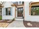 Charming home entrance with a beautiful wood door, stone walkway, and neat landscaping at 5485 Woodrun Ln, Johns Creek, GA 30005