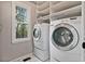 Bright laundry room features a side-by-side washer and dryer and ample shelving at 5485 Woodrun Ln, Johns Creek, GA 30005