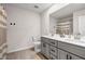 Bathroom featuring double sinks with white countertops, gray cabinets, and a framed mirror at 787 Milo Bay Street, Loganville, GA 30052