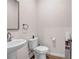 Clean half bathroom with a pedestal sink and a minimalist design at 787 Milo Bay Street, Loganville, GA 30052