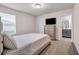 Bedroom featuring a bed with a patterned comforter, dresser with a TV, and a view into the bathroom at 787 Milo Bay Street, Loganville, GA 30052
