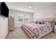 Bright bedroom with two windows, a TV, dresser, and bed with a festive red and white patterned comforter at 787 Milo Bay Street, Loganville, GA 30052