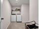 Laundry room featuring a washer and dryer, tile floors, and a metal shelf at 787 Milo Bay Street, Loganville, GA 30052