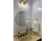 Bright bathroom featuring a round mirror, decorative light fixture, and neutral-toned countertop at 908 Chippendale Ln, Norcross, GA 30093