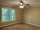 Cozy bedroom with a ceiling fan, neutral walls, carpet flooring, and bright windows at 908 Chippendale Ln, Norcross, GA 30093