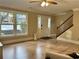 Bright living room featuring hardwood floors, staircase, and large windows offering natural light at 908 Chippendale Ln, Norcross, GA 30093