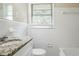 Bathroom featuring granite vanity, tub with tiled walls, and natural light at 1973 Columbia Dr, Decatur, GA 30032