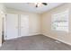 A bright bedroom with neutral walls, plush carpet, a ceiling fan and two entry doors at 1973 Columbia Dr, Decatur, GA 30032