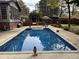 Inviting pool area surrounded by a paved patio, outdoor furniture, and well-manicured landscaping at 2112 Fisher Ne Trl, Atlanta, GA 30345