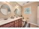 Bathroom featuring double sinks with dark wood cabinets and a round mirror above each at 24 Laurel Ne Way, White, GA 30184